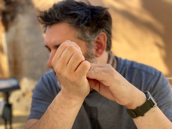 Close-up portrait of man holding hands