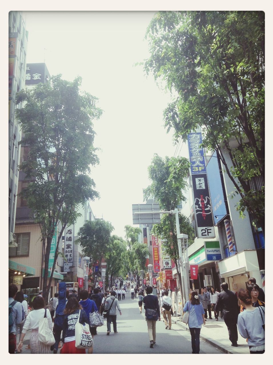 men, transfer print, large group of people, person, street, city, walking, building exterior, city life, tree, architecture, lifestyles, built structure, auto post production filter, transportation, road, leisure activity, clear sky, city street