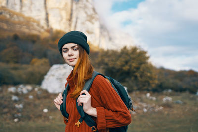 Portrait of young woman standing in park during winter