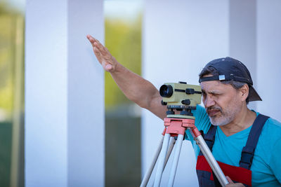 Side view of man photographing with camera