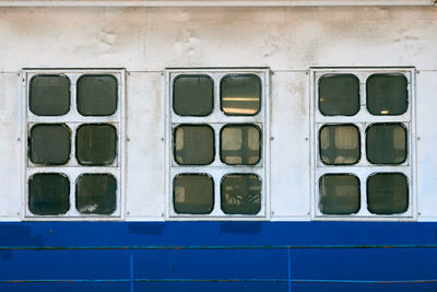 Cabin windows and portholes on outboard side of ship. close up of hull of vintage ocean liner