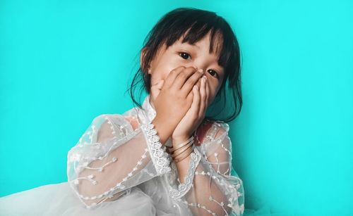 Portrait of woman against blue background