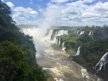 Scenic view of waterfall against sky