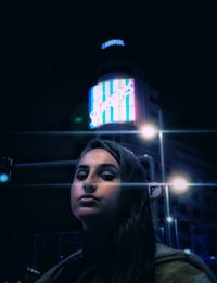 Portrait of young woman looking away at night