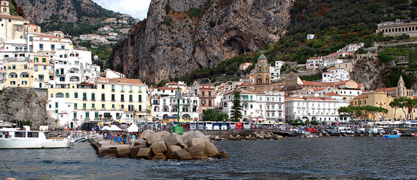 Buildings by sea against mountain