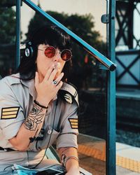 Portrait of young man wearing sunglasses sitting outdoors