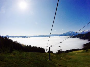 Overhead cable car over mountains against sky