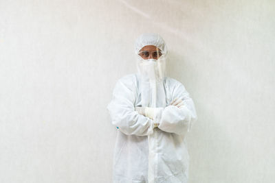 Portrait of young man wearing mask against white background