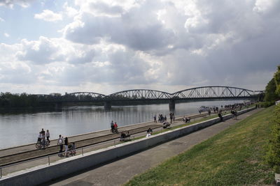 Bridge over river against cloudy sky