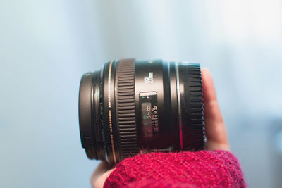 Cropped image of hand holding camera lens
