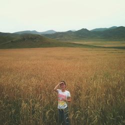 Portrait of woman standing on field against sky