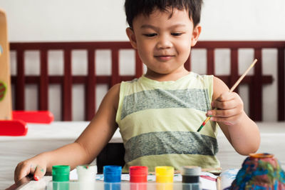 Cute boy painting at home