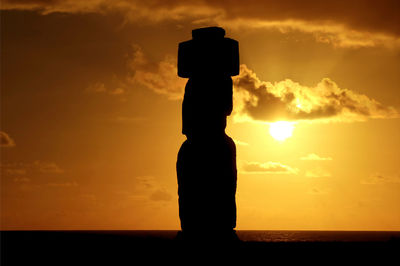 Silhouette man standing by sea against sky during sunset