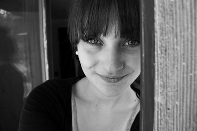 Black and white portrait of young woman with bangs smiling