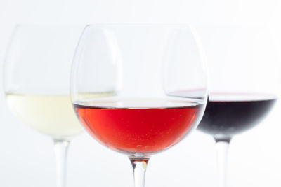 Close-up of wineglasses against white background