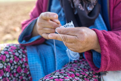 Midsection of woman holding doing crochet