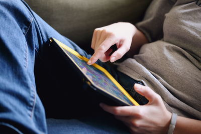 Midsection of woman using digital tablet