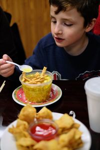 Boy having food at table