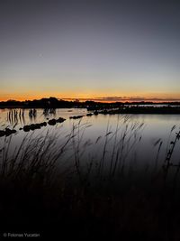 Scenic view of lake against sky during sunset