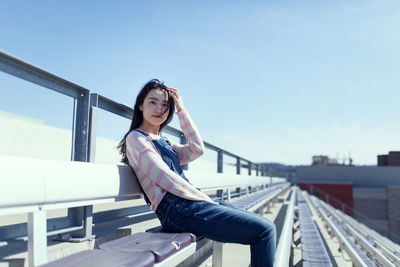 Young woman sitting on stadium seat