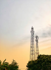 Low angle view of communications tower against sky during sunset