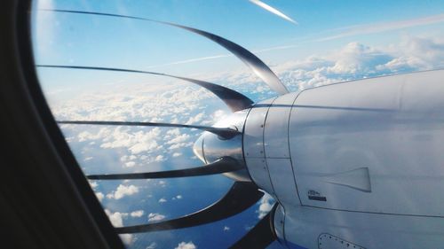 Close-up of airplane wing against cloudy sky