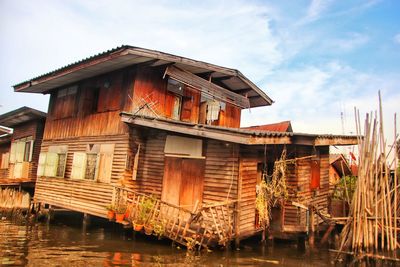 Exterior of house by river against sky