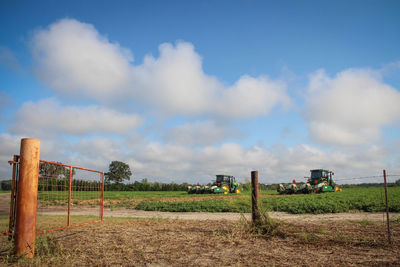 Agricultural machineries at farm against sky