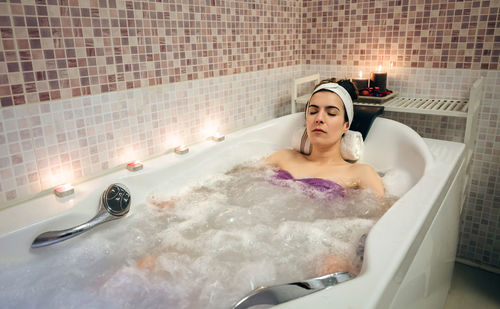 Young woman in bathtub at home