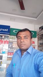 Portrait of young man standing in store