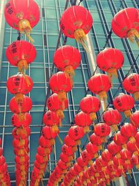 Low angle view of chinese lanterns hanging against building on sunny day
