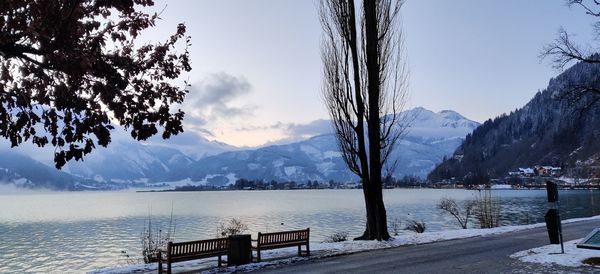 Scenic view of lake by snowcapped mountains against sky