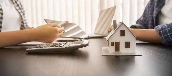 Midsection of woman using calculator on table