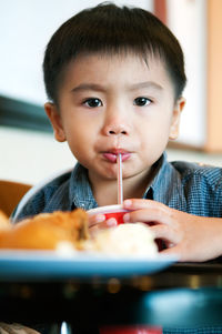 Close-up portrait of boy having drink