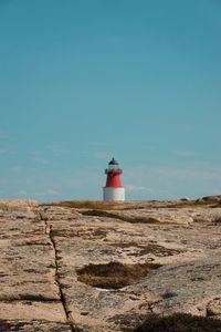 Lighthouse on rock against sky