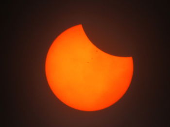 Close-up of orange moon against clear sky at night