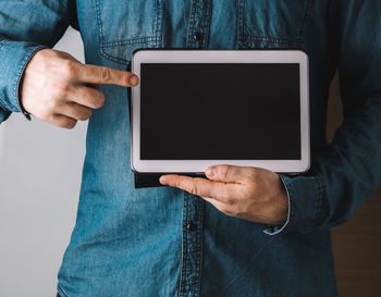 Midsection of man using mobile phone