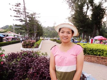 Portrait of smiling young woman standing in park