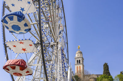 Low angle view of ferris wheel against clear blue sky