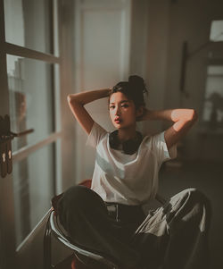 Portrait of woman sitting on chair at home