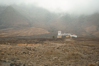 Scenic view of land and mountains against sky