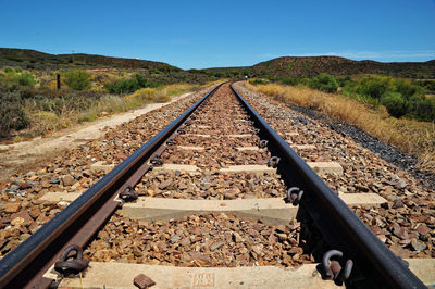 Railroad track passing through land against sky