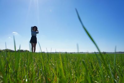 Woman standing on field against sky