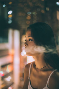 Side view of young woman looking away outdoors