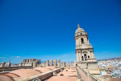 Buildings in city against blue sky