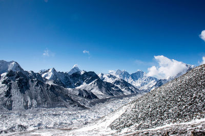 Scenic view of snowcapped mountains against blue sky