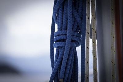 Close-up of rope tied on metallic structure against sky