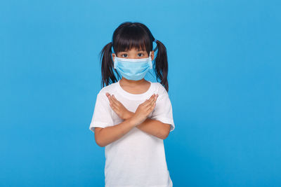 Portrait of a girl holding blue background