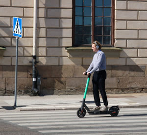 Full length of man walking on footpath in city