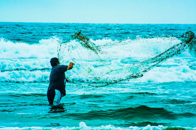 Full length of man standing in sea against sky